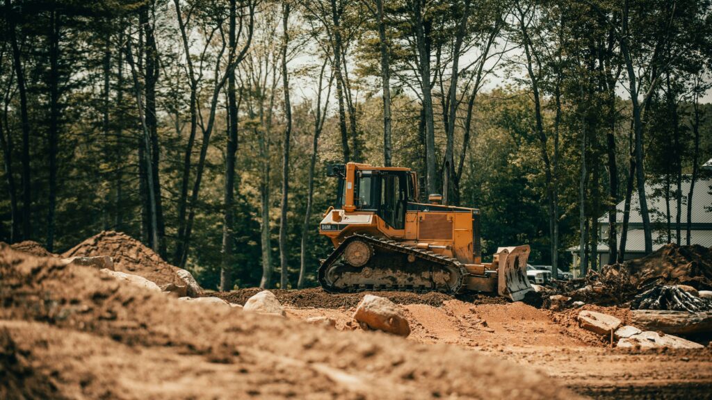 Bulldozer in woods pushing dirt